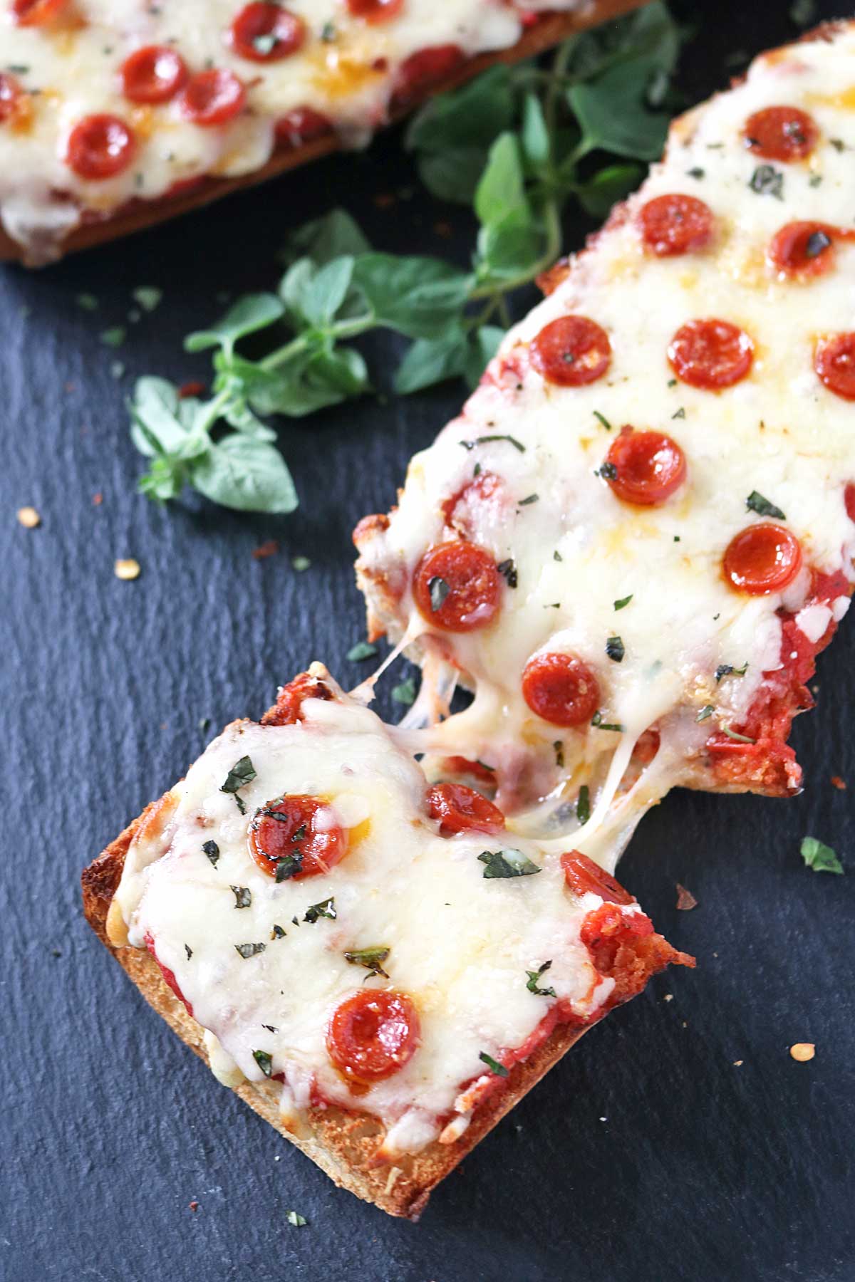 A picture of Pepperoni French Bread Pizza on a black serving dish.